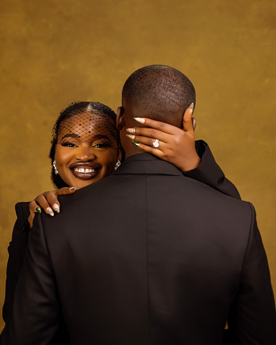 Adewunmi smiling over David's shoulder